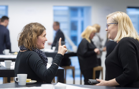Two women discussing in a cafeteria