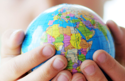 Lapsi pitää käsissään pientä maapalloa