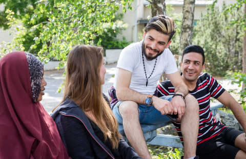 Henkilöitä keskustelemassa ulkona