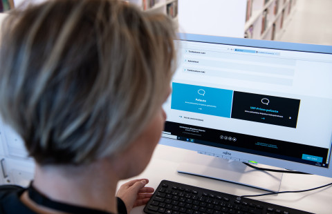 Nainen valitsee lomaketta tietokoneella.