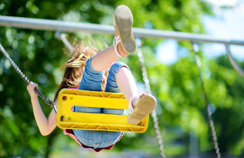Lapsi keinuu leikkipuistossa