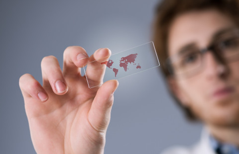 Researcher holding a microscope slide in his hand