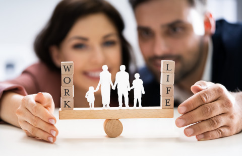 Ihmishahmoja ja kirjainpalikoita kiikkulaudalla