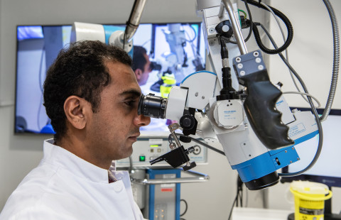 Man working with a microscope.