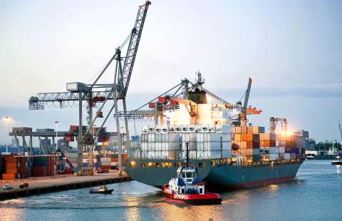 Kontteja lastataan tankkeriin satamassa.