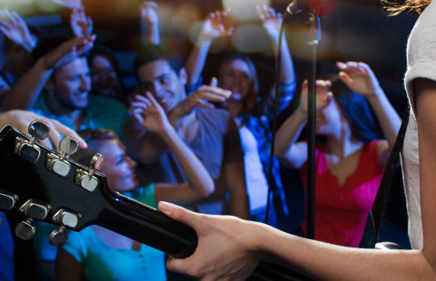 Kitaristi esiintyy yleisön edessä.