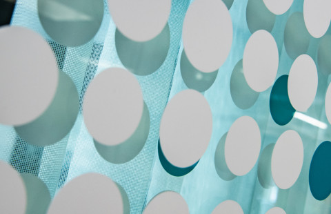 Pyöreitä tarroja lasiseinällä.