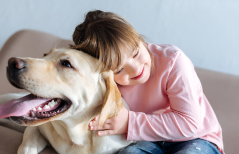 Lapsi ja koira sohvalla