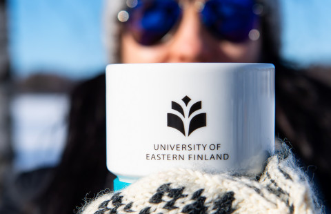Woman holding a UEF mug.