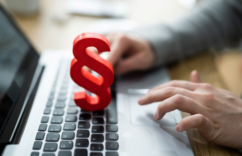 Punainen lakipykälä-merkki kannettavan tietokoneen näppäimistön päällä