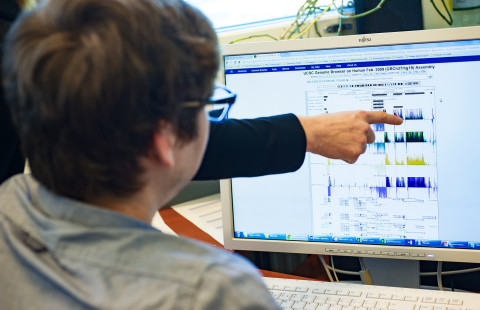 Two people examining research results on a computer screen.