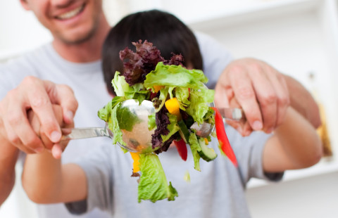 Mies ja lapsi valmistavat salaattia.