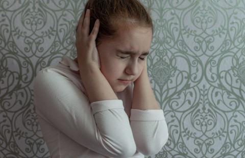 Tyttö pitelee korviaan