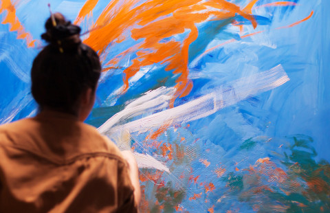 Tyttö maalaa taideteosta.