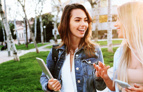 Ystävykset keskustelevat puistossa.