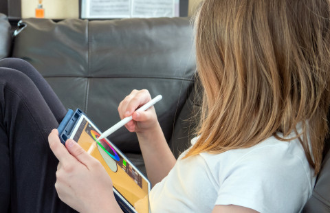 Tyttö piirtää tabletilla.