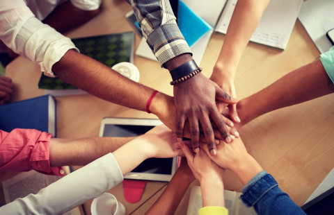 Lähikuva kansainvälisen opiskelijaryhmän käsistä päällekkäin 