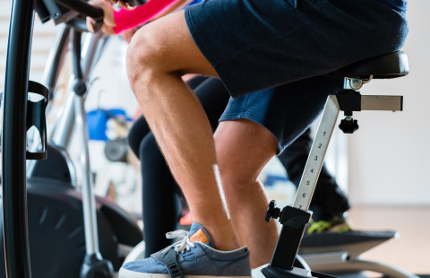 Man pedaling on exercise bicycle.