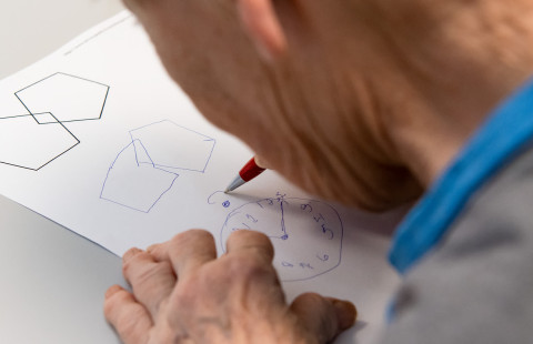 Elderly patient performing a drawing test.
