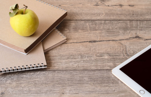 Padi, vihkoja ja omena puisella pöydällä