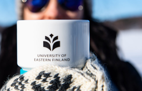 Woman holding a UEF mug in her hands.