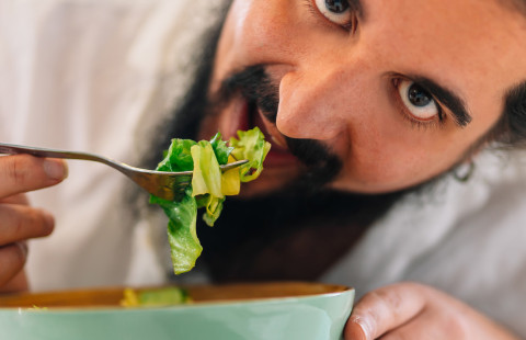 Mies syö salaattia.