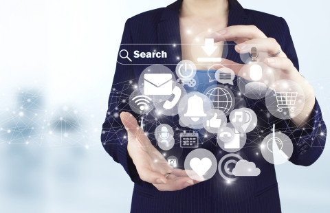 Henkilö pitää käsissään somekuvakkeiden pilveä.