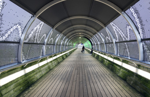 People walking in tunnel.