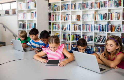 Lapset käyttävät tietokoneita.