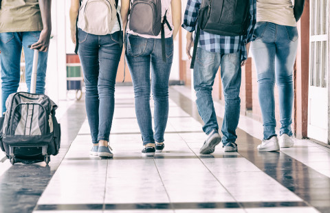 Teenagers in school hallway.
