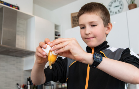 Boy cracking an egg.