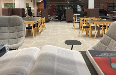 Kuopion kampuskirjaston tiloissa nojatuoleja ja työpöytiä.