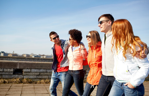 Teenagers walking on city street.