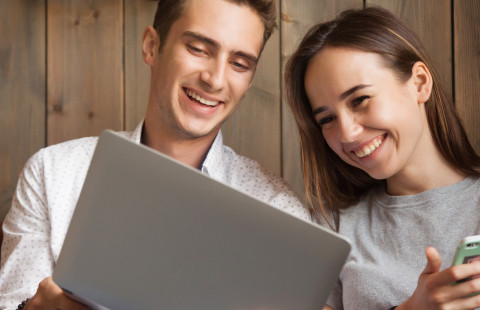 Mies ja nainen työskentelevät kannettavalla tietokoneella.