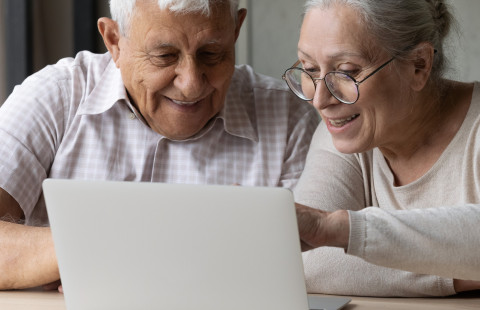 Vanha mies ja nainen tietokoneen ääressä.