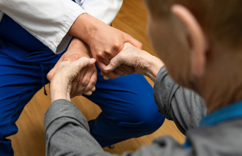 Potilas puristaa lääkärin käsiä.