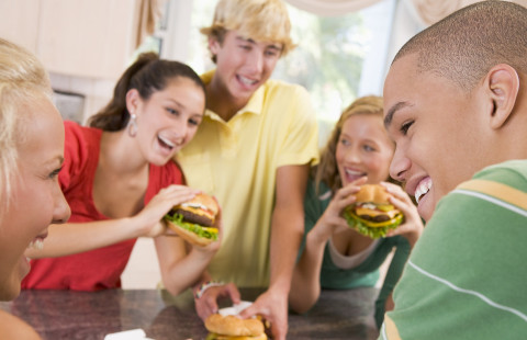 Nuorisoa hampurilaisella.