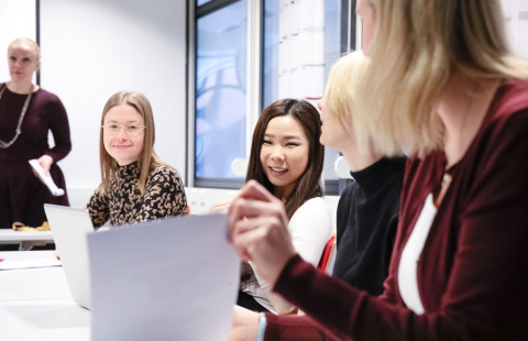 Opiskelijat ja henkilöstö yhteisen neuvottelupöydän äärellä.