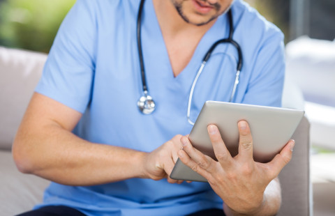 Sairaanhoitaja kirjaa tabletille.