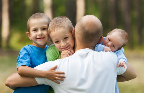 Isä ja lapset halaavat.