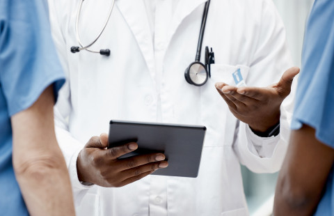 Lääkäreitä tabletti kädessä.