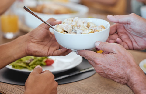 Ruokapöydässä ojennetaan salaattia.