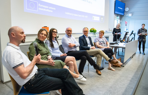 Ihmisiä paneelikeskustelussa.