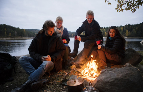 Ihmisiä leirinuotiolla.