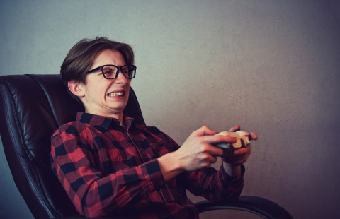 Nuori pelaa videopeliä vihaisena.