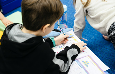 Alakoulun oppilas tekemässä matematiikan tehtäviä.