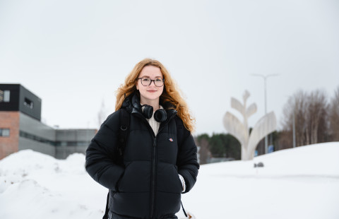 Yuliia Maliienko ulkona yliopiston Kasvu-teoksen edessä.