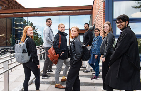 Students standing on stairs outdoors.