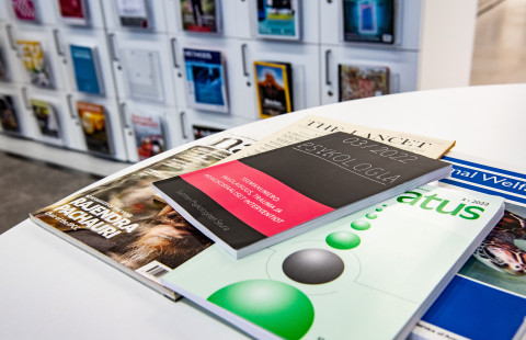 Tieteellisiä lehtiä pöydällä ja lehtikaapissa.