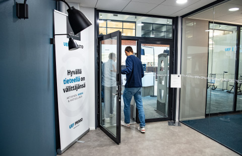 Kaksi ihmistä menossa kirjaston ovesta sisälle.